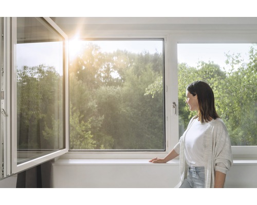 Otvorené okno v jasnej miestnosti s výhľadom na stromy