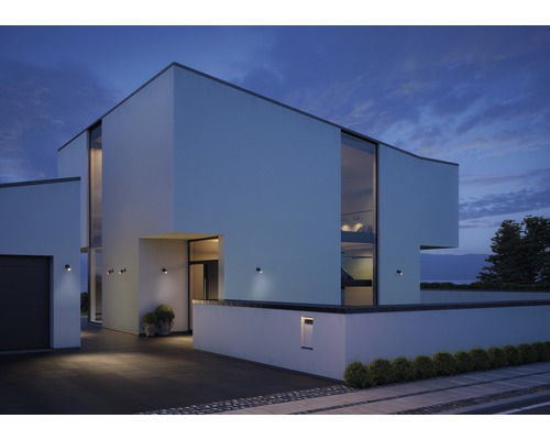Moderný dom s vonkajším osvetlením a veľkými oknami za súmraku