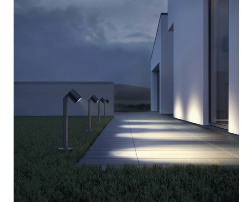 Rad záhradných svietidiel pozdĺž chodníka pred moderným domom