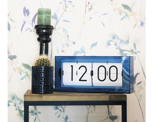 Dekoratívna scéna s preklápacími hodinami, sviečkou a kaktusom na poličke