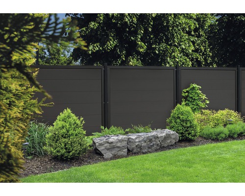 Záhrada s moderným plotom a okrasnými rastlinami