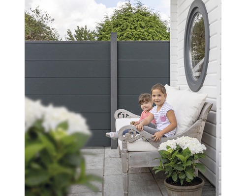 Ochranný plot so sediacimi deťmi na lavičke v záhrade