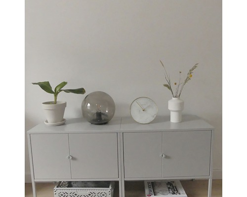 Príborník s izbovou rastlinou, stolnou lampou, hodinami a vázou