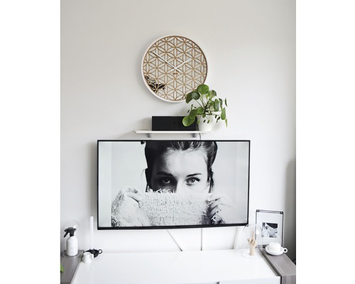 Obývacia izba s geometrickými nástennými hodinami a televíziou