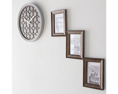 Nástenné hodiny a tri fotorámiky na stene