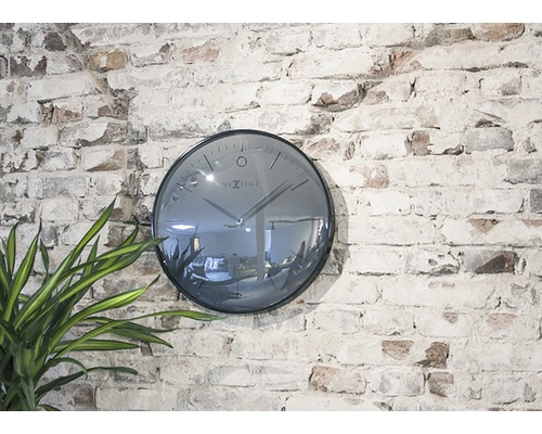 Nástenné hodiny Nextime na tehlovej stene