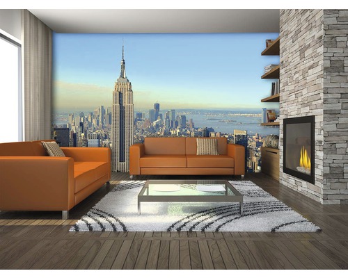 Obývacia izba s fotografickou tapetou New York, pohovky, konferenčný stolík, krb a knižnica