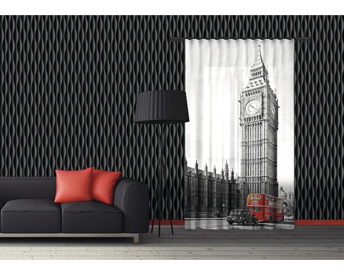Obývacia izba s čiernou pohovkou, stojacou lampou, stenovými panelmi a ozdobným závesom s motívom Big Benu