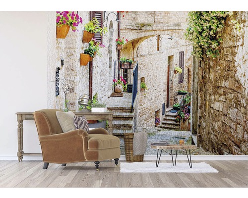 Obývacia izba s kreslom, stolom a fototapetou s uličkou v Taliansku.