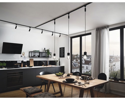 Svetlá kuchyňa s jedálenským stolom, stoličkami a čiernym kuchynským kútom pod koľajnicovým osvetlením