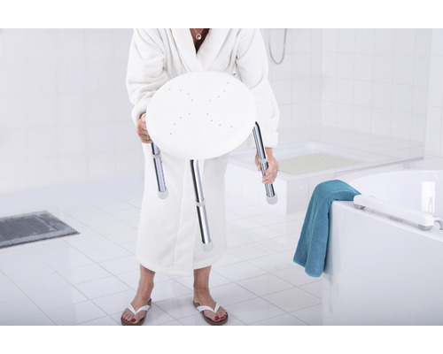 Žena v župane drží sprchovú stoličku