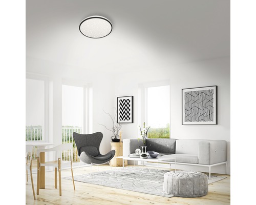 Svetlá obývacia izba so stropným svietidlom, pohovkou a dekoráciou