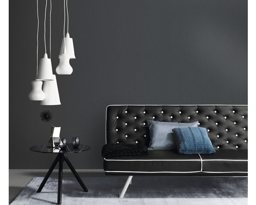 Obývacia izba s čiernou pohovkou, príručným stolíkom a závesnými svietidlami