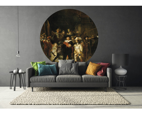 Obývacia izba s pohovkou, kobercom a okrúhlou nástennou dekoráciou s motívom maľby