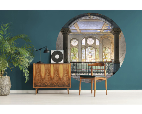 Dizajn izby s komodou, izbovou rastlinou a nástennou maľbou s výhľadom na budovu