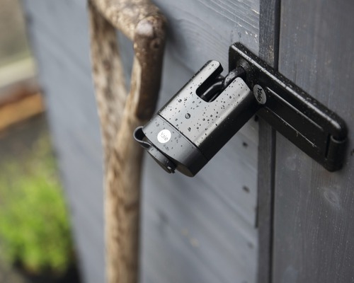 Visiaci zámok s logom Yale na drevených dverách