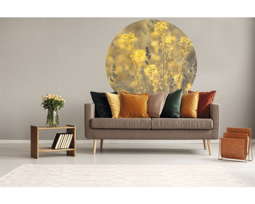 Obývacia izba s pohovkou, vankúšmi a nástennou dekoráciou s rastlinným motívom