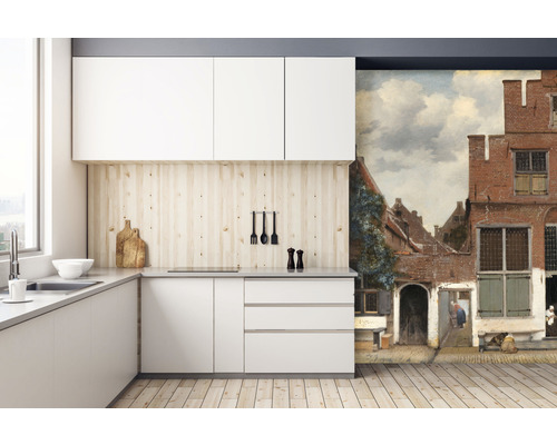 Moderná kuchyňa s bielymi skrinkami, drevenou pracovnou doskou a nástennou maľbou