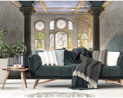 Obývacia izba s pohovkou, vankúšmi, dekou a nástennou tapetou s architektonickým vzorom