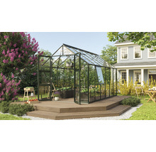 Skleník s rastlinami na drevenej terase v záhrade.