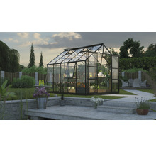 Skleník s rastlinami a záhradnými doplnkami v záhrade