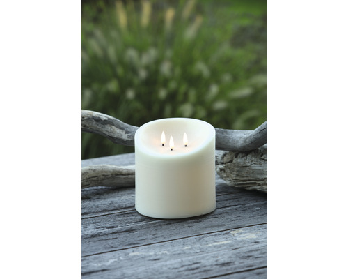 Dekoratívna stĺpová sviečka s tromi knôtmi na drevenom stole