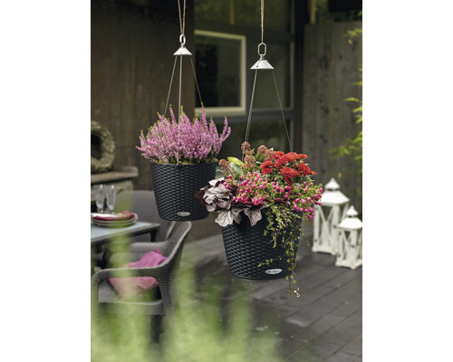 Dva závesné kvetináče s kvetinami na terase.