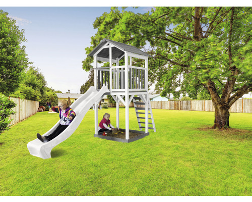 Hracia veža so šmýkačkou a pieskoviskom v záhrade s hrajúcimi sa deťmi