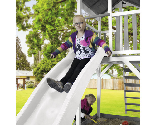 Dieťa sa kĺže na šmýkačke na ihrisku v záhrade.