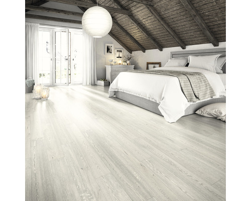 Svetlá spálňa so šikmou strechou, drevenými trámami a svetlou drevenou podlahou