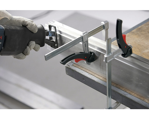 Priamočiara píla reže kovový profil upevnený skrutkovými svorkami.