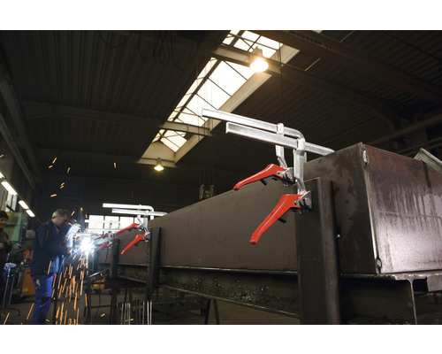 Zvárač pracuje na kuse kovu, ktorý je upevnený pomocou rýchloupínacích svoriek.