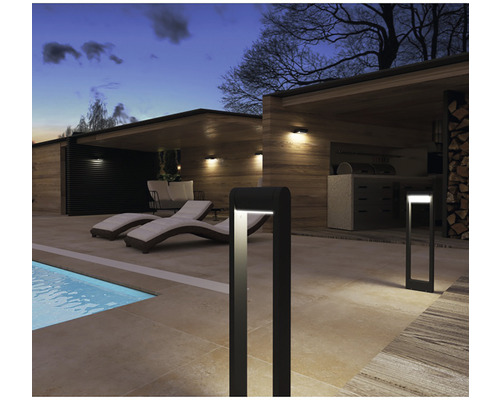 Scéna s vonkajším osvetlením, ležadlami pri bazéne a vonkajšou kuchyňou.