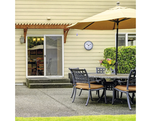 Terasa so stolom, stoličkami, slnečníkom a hodinami na stene