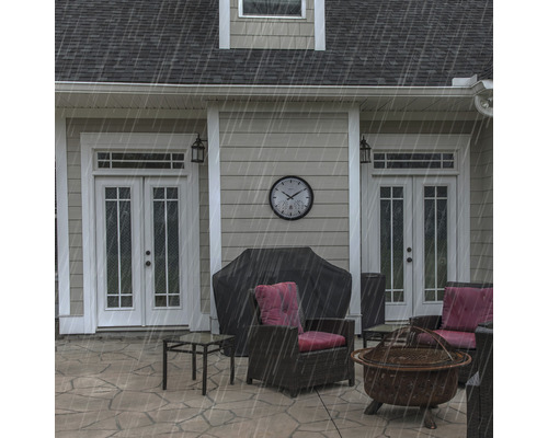 Záhradný nábytok na terase s grilom pod krytom a vonkajšími nástennými hodinami v daždi