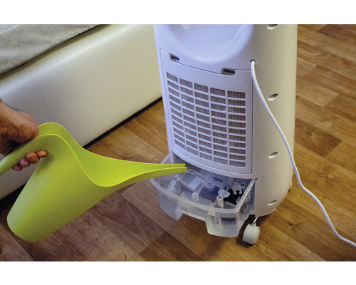 Osoba nalieva vodu do mobilného ochladzovača vzduchu zelenou kanvou