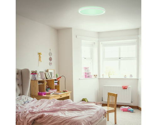 Svetlá detská izba s posteľou, písacím stolom a okrúhlym stropným svietidlom