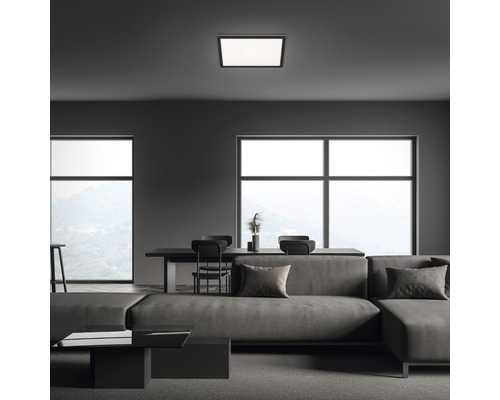 Moderná obývacia izba so štvorcovým stropným svietidlom, pohovkou, stolom a oknami