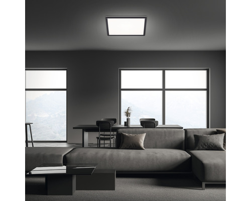 Moderná obývacia izba so štvorcovým stropným svietidlom, pohovkou a jedálenským stolom