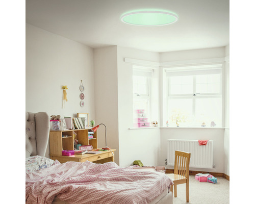 Svetlá detská izba s posteľou, písacím stolom a okrúhlym stropným svietidlom