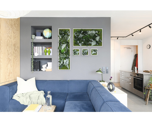 Obývacia izba s modrou pohovkou a nástennou dekoráciou z rastlinných obrazov