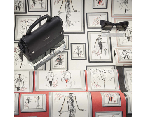 Čierna kabelka Karl Lagerfeld a slnečné okuliare pred stenou s módnymi kresbami.