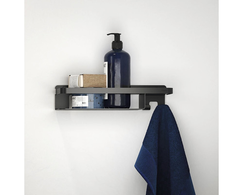 Čierna nástenná polica s uterákom a kúpeľňovými potrebami