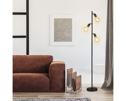 Obývacia izba so stojacou lampou, pohovkou a stojanom na časopisy