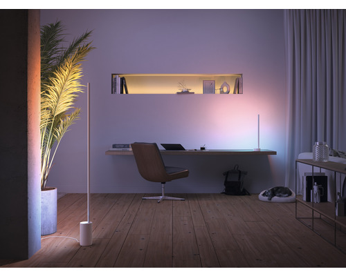 Obývacia izba so stolom, stojacími lampami a izbovou rastlinou