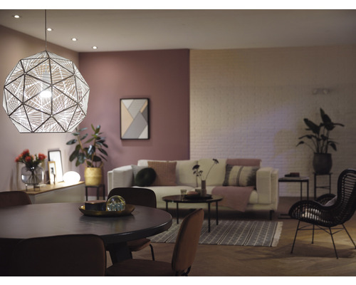 Obývacia izba s jedálenským stolom, pohovkou a geometrickým závesným svietidlom