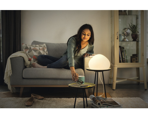 Žena na pohovke so stolnou lampou v obývacej izbe