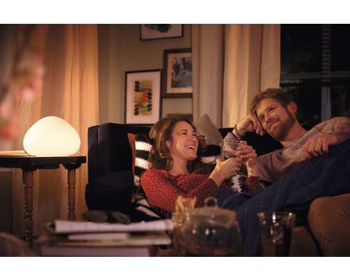 Pár relaxuje v obývací izbe s dekoratívnou stolnou lampou