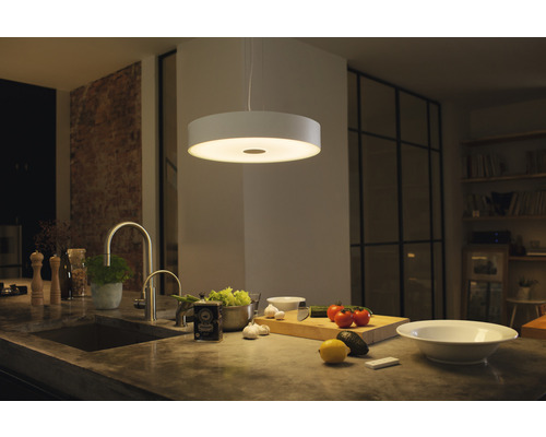 Moderná kuchyňa s okrúhlym závesným svietidlom nad pracovnou doskou.