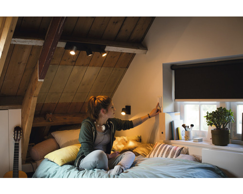 Mládežnícka izba s šikmou strechou, posteľou, oknom s roletou, gitarou a osvetlením